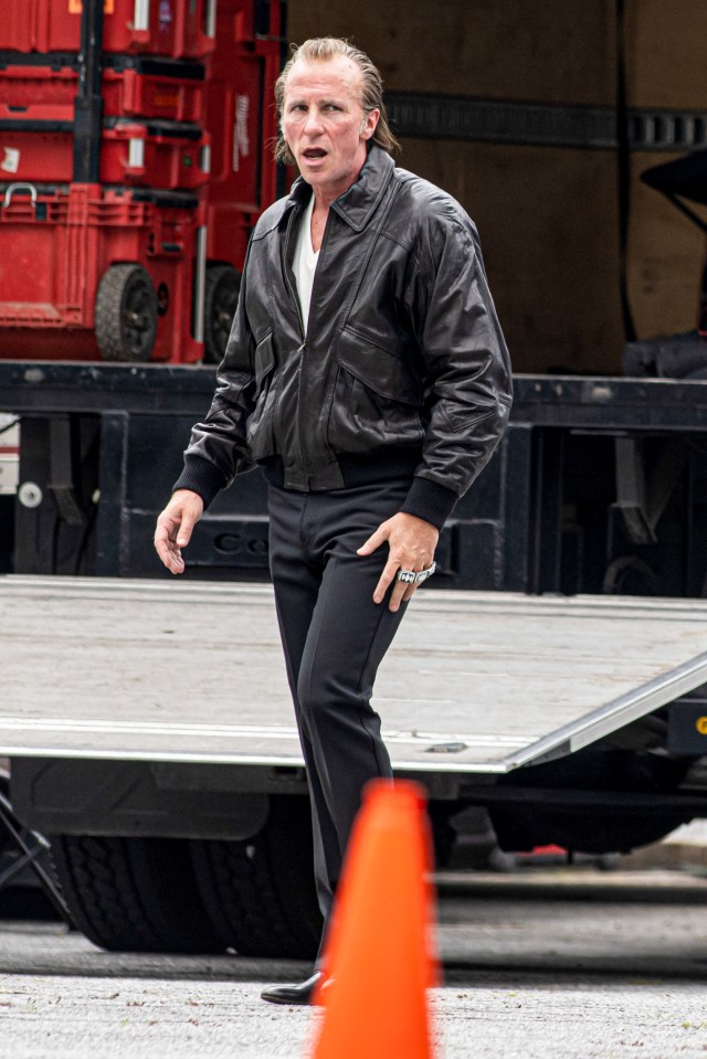 Christian Bale on the set of "Madden," wearing a leather jacket and rings.
