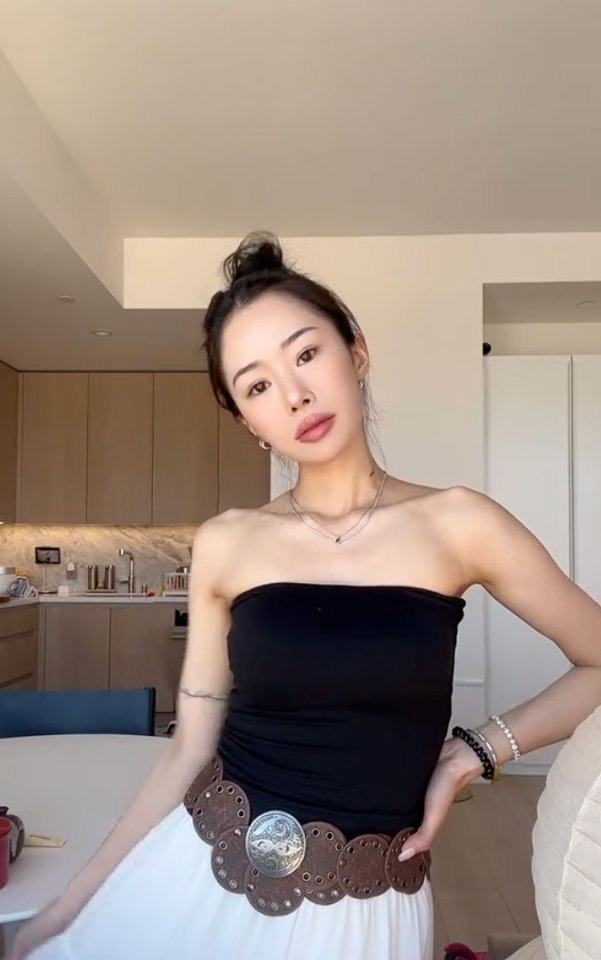 Woman wearing a black tube top and wide belt.
