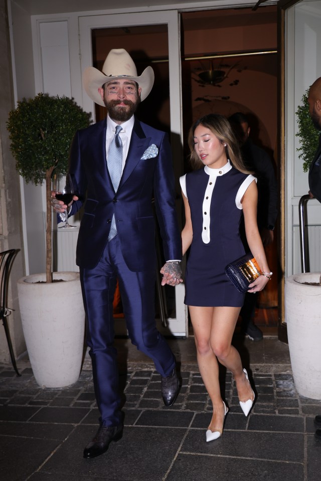 Post Malone and Christy Lee holding hands leaving a restaurant.