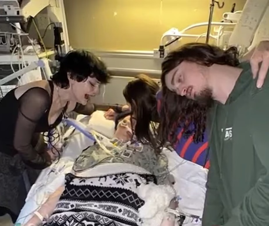 Grieving family members at a hospital bedside.