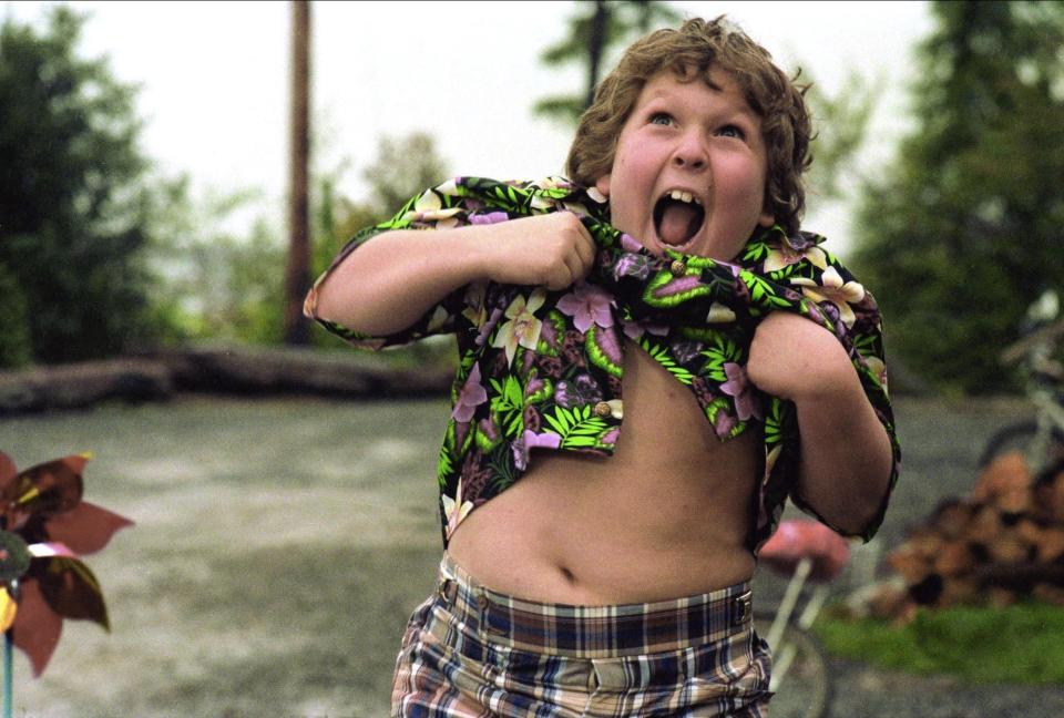 Still from *The Goonies* showing Chunk in a floral shirt.
