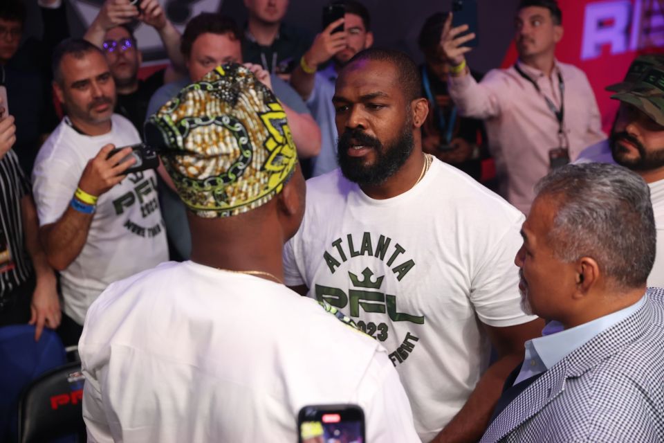 a man wearing an atlanta shirt talks to another man