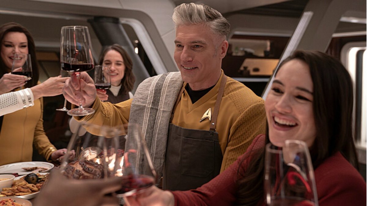 Captain Pike (Anson Mount) toasts the Enterprise crew on Star Trek: Strange New Worlds.