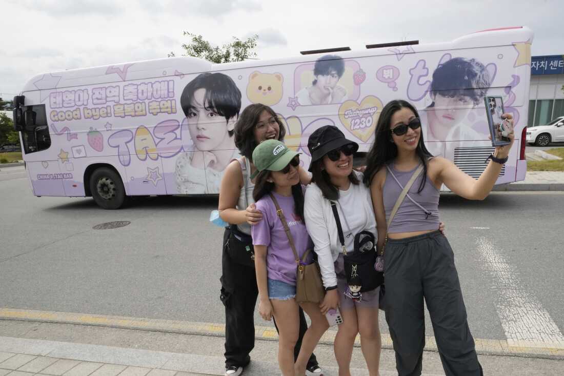 Fans take photos after K-pop band BTS members RM and V are discharged from a mandatory military service in Chuncheon, South Korea on Tuesday.