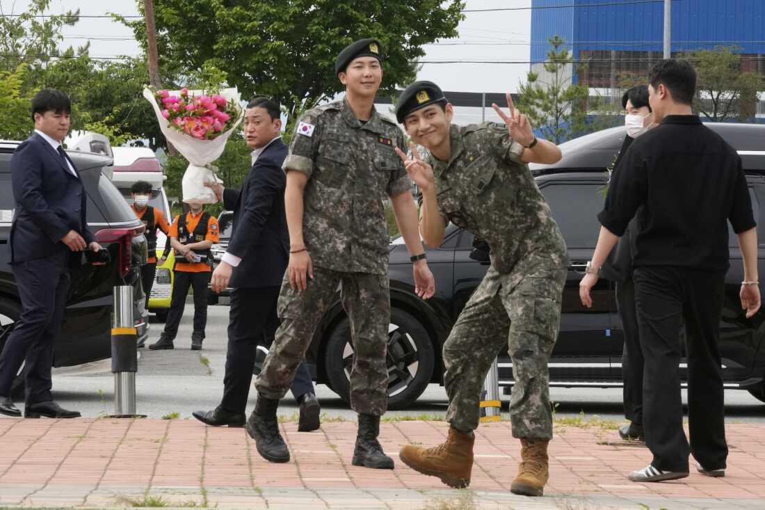 K-pop band BTS members RM, center left, and V, center right, react after being discharged from a mandatory military service in Chuncheon, South Korea on Tuesday.
