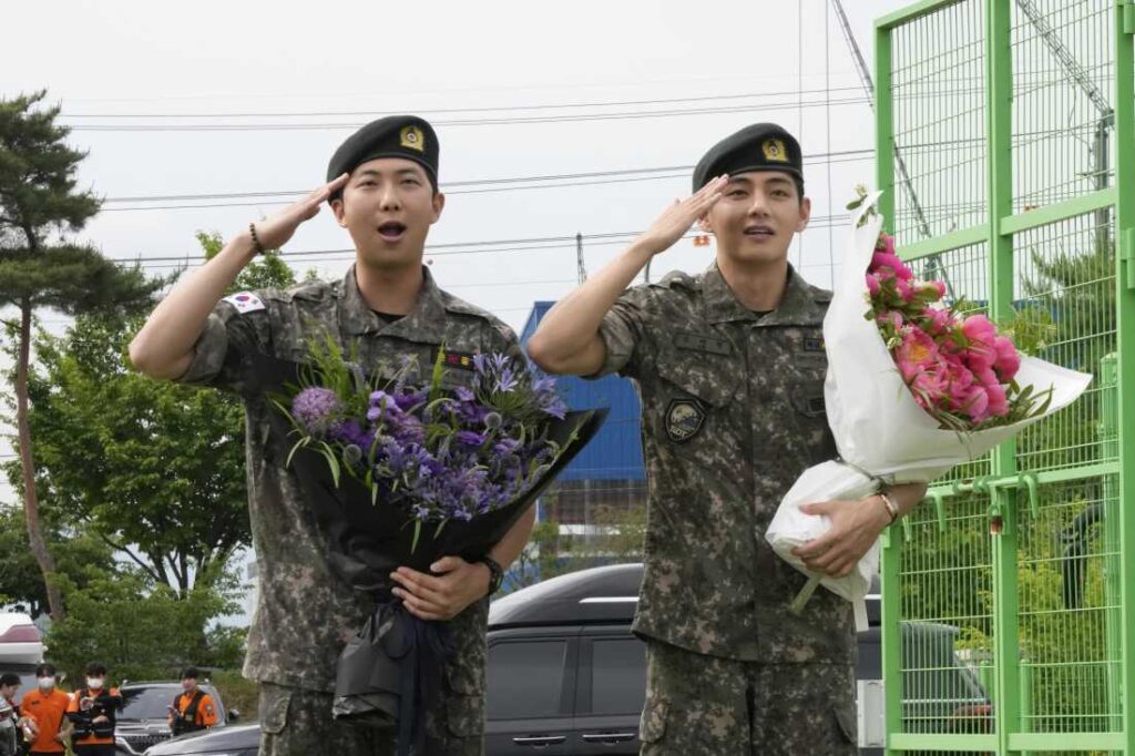 K-pop band BTS members RM, left, and V salute after being discharged from a mandatory military service in Chuncheon, South Korea, on Tuesday.