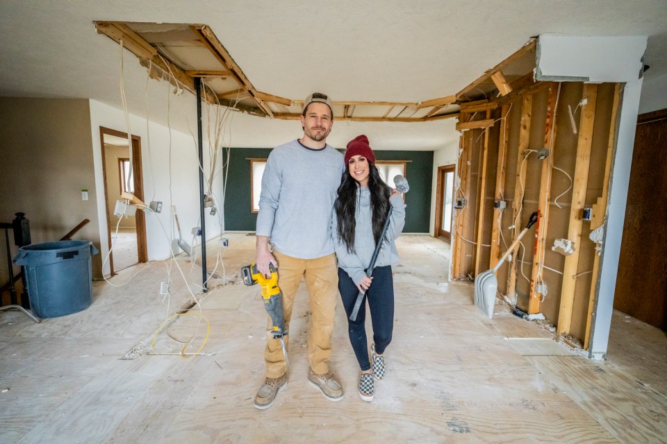 Couple standing in a room undergoing demolition.