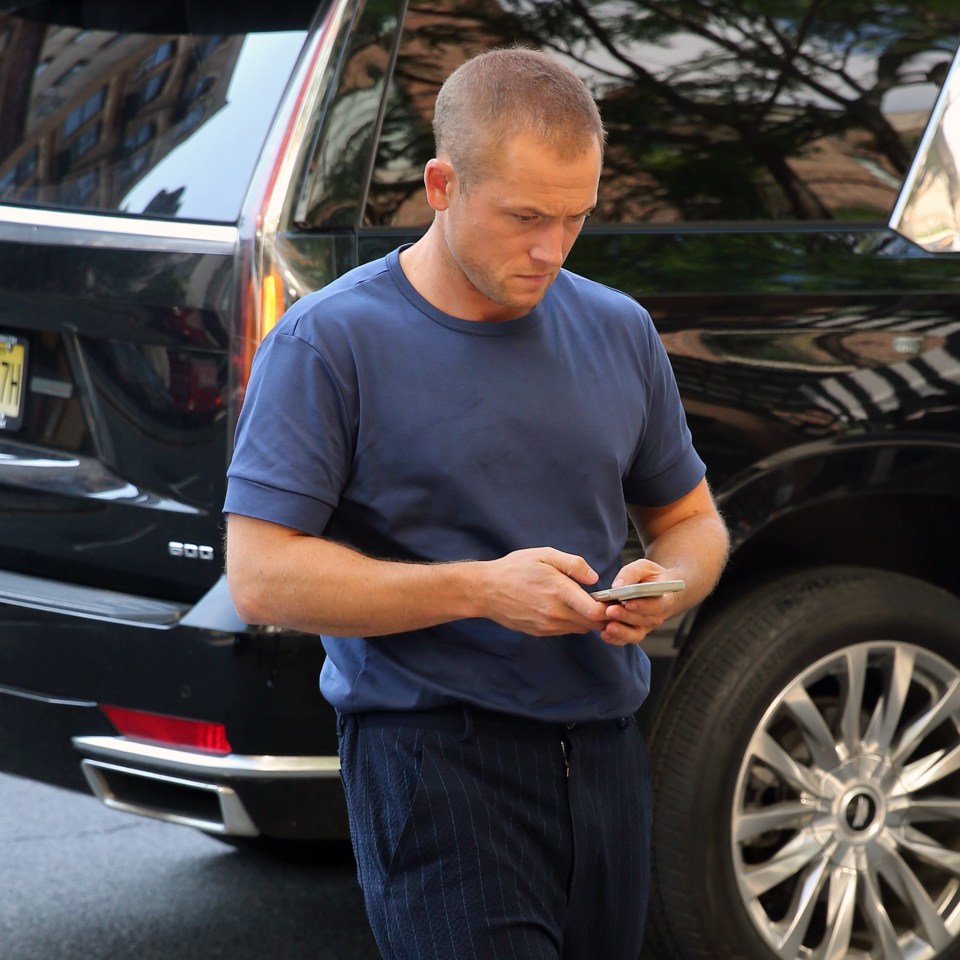 Taron Egerton using a cell phone.