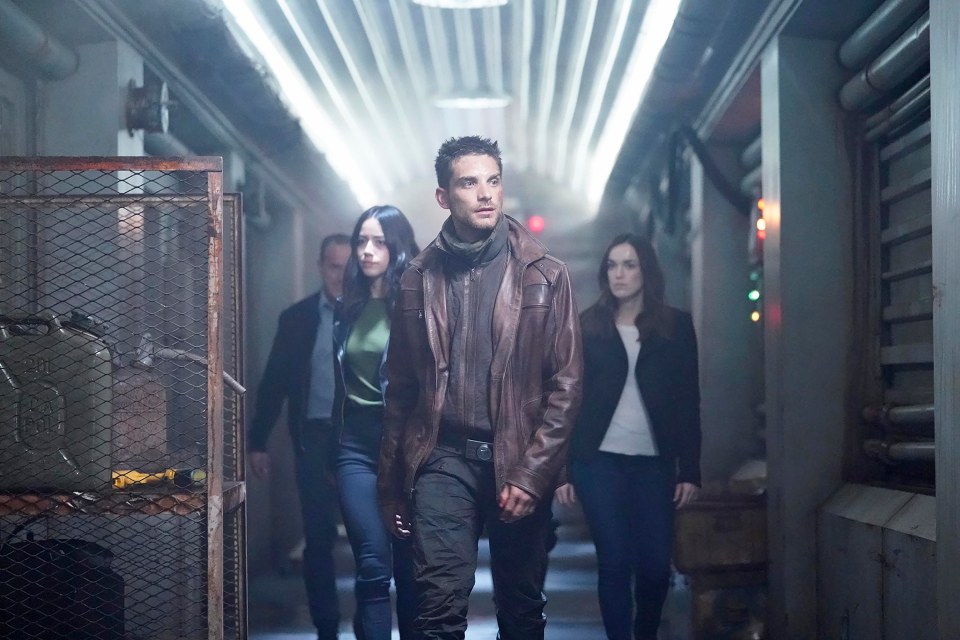 Clark Gregg, Chloe Bennet, Jeff Ward, and Elizabeth Henstridge walking down a hallway.