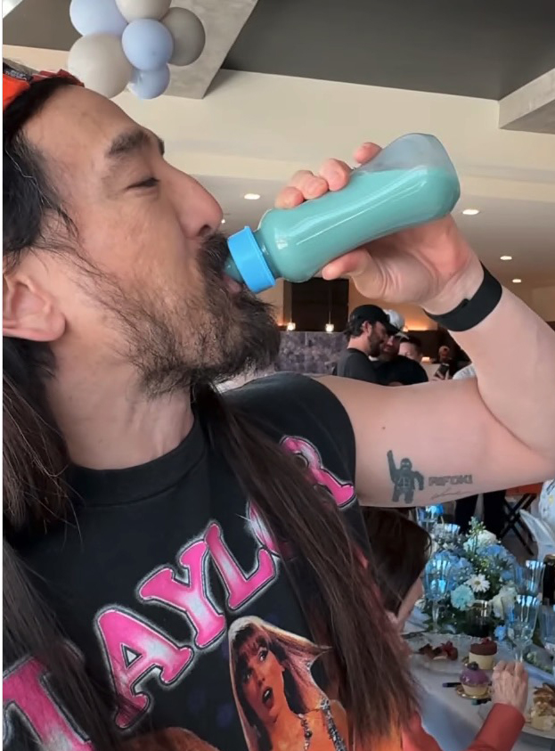Steve Aoki drinking from a baby bottle.