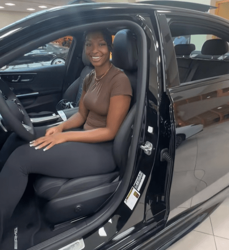 Woman sitting in a black car.