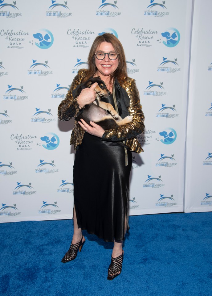 Rachael Ray holding a small dog at an animal rescue gala.
