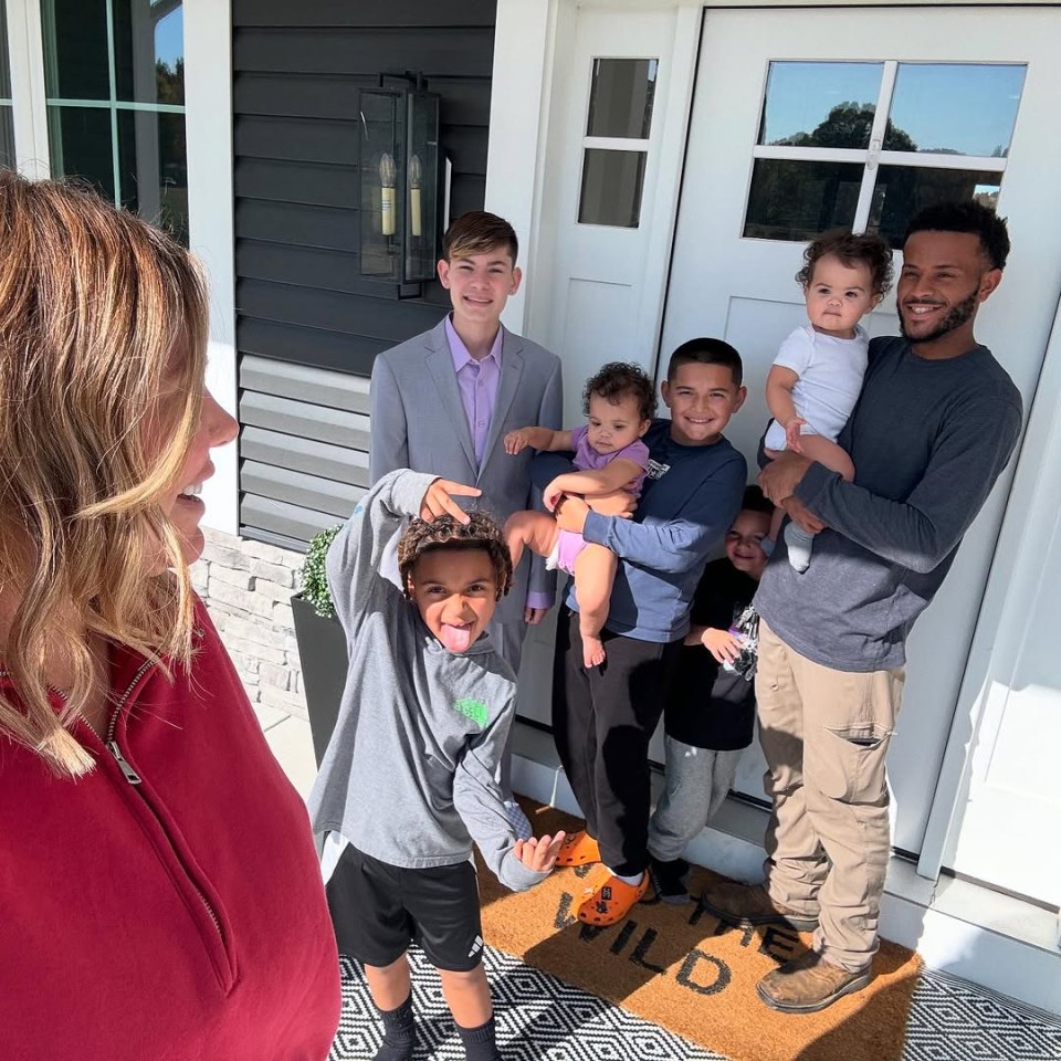 Family of seven posing on their porch.