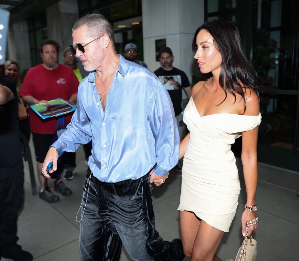 Brad Pitt and Ines de Ramon walking hand-in-hand.