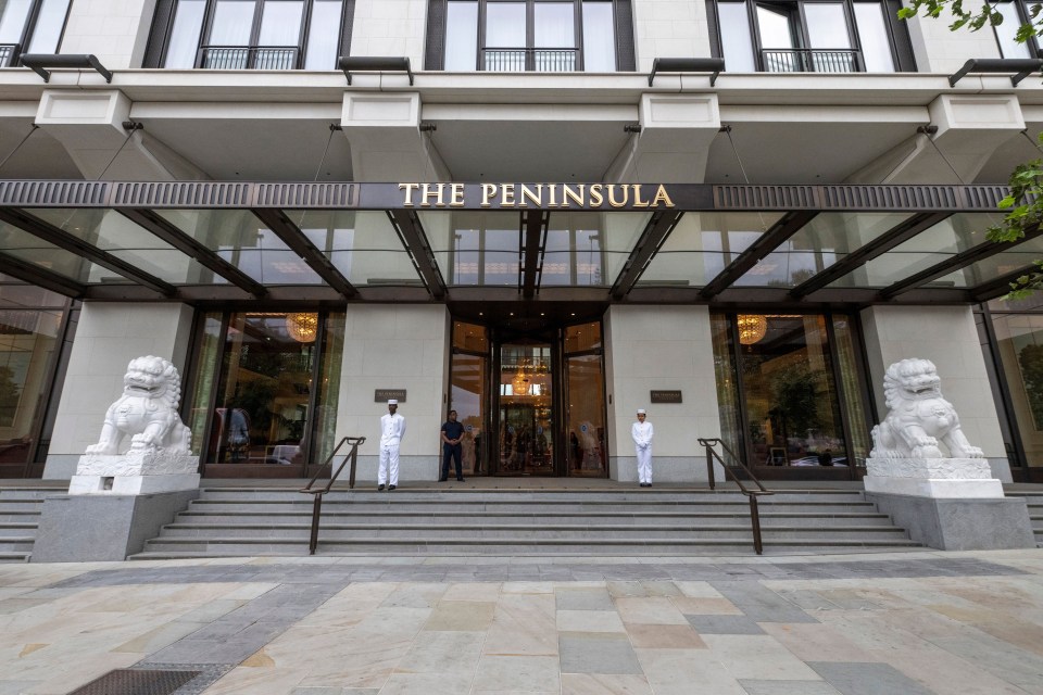 The Peninsula Hotel entrance in London, with staff and lion statues.