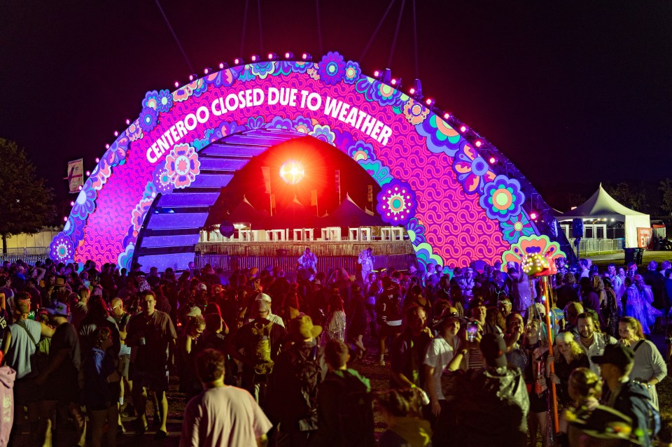 Disappointed Bonnaroo attendees at a festival arch that reads "Bonnaroo Closed Due to Weather".