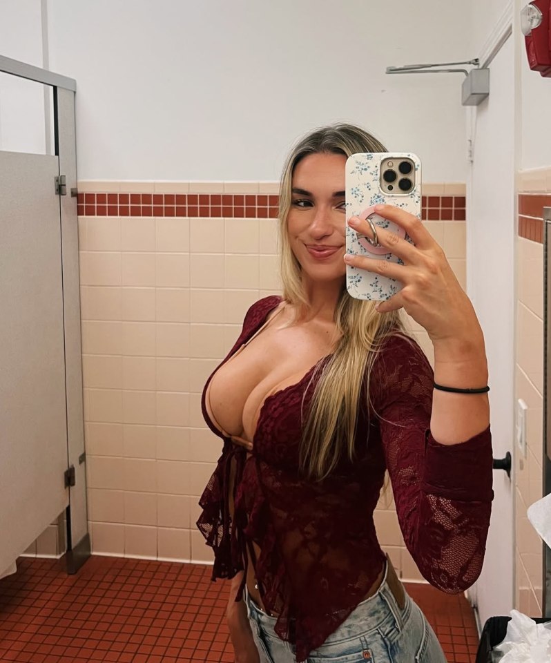 Woman taking a selfie in a restroom.