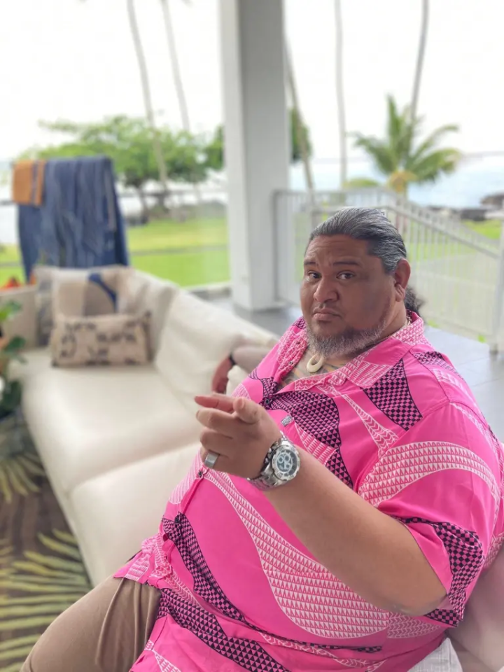 Man in pink shirt gesturing.