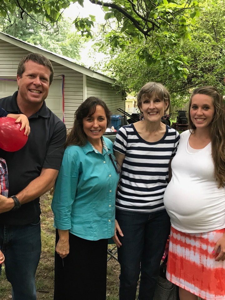 Photo of four people standing outdoors.