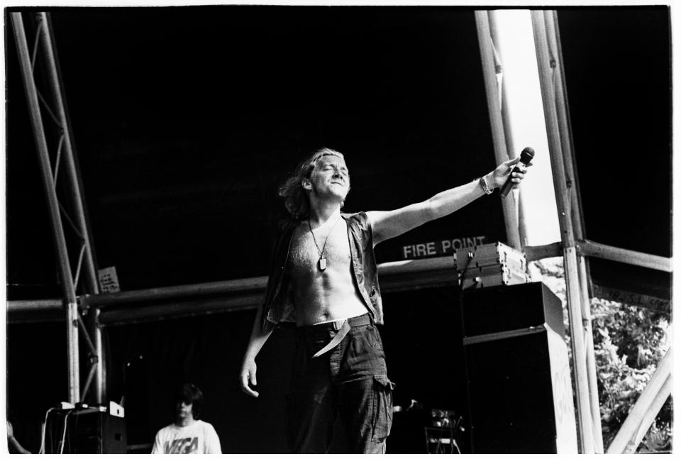 Black and white photo of John Reid of Nightcrawlers performing at a music festival.