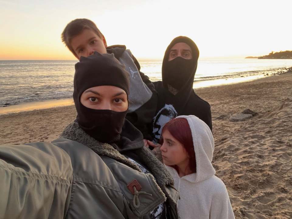 Family selfie at the beach at sunset.