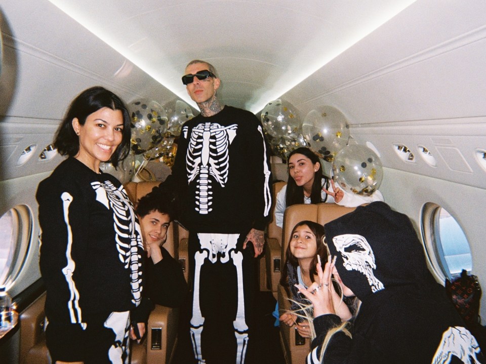 Family in skeleton costumes on a private jet with balloons.