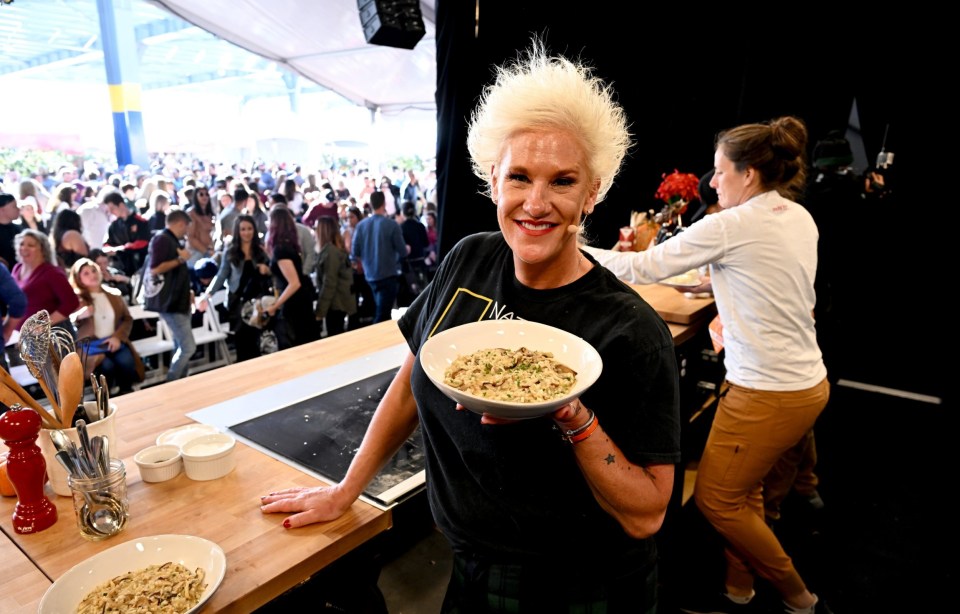 Anne Burrell presenting a dish at a food festival.