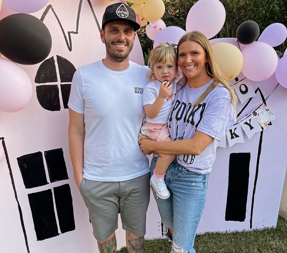 Family photo in front of a Halloween-themed backdrop.