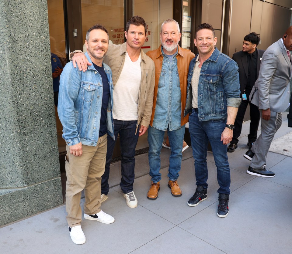 Four members of the 98 Degrees band posing for a photo.