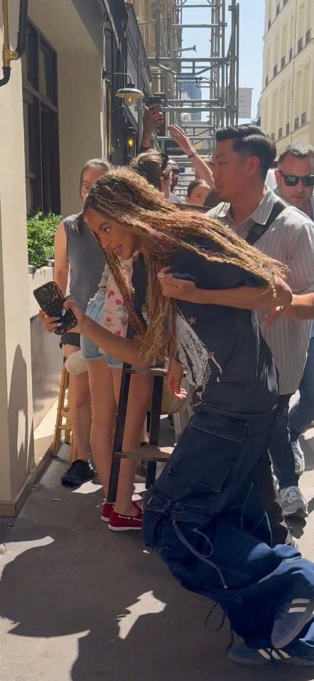 Blue Ivy and Jay-Z in Paris, surrounded by fans.