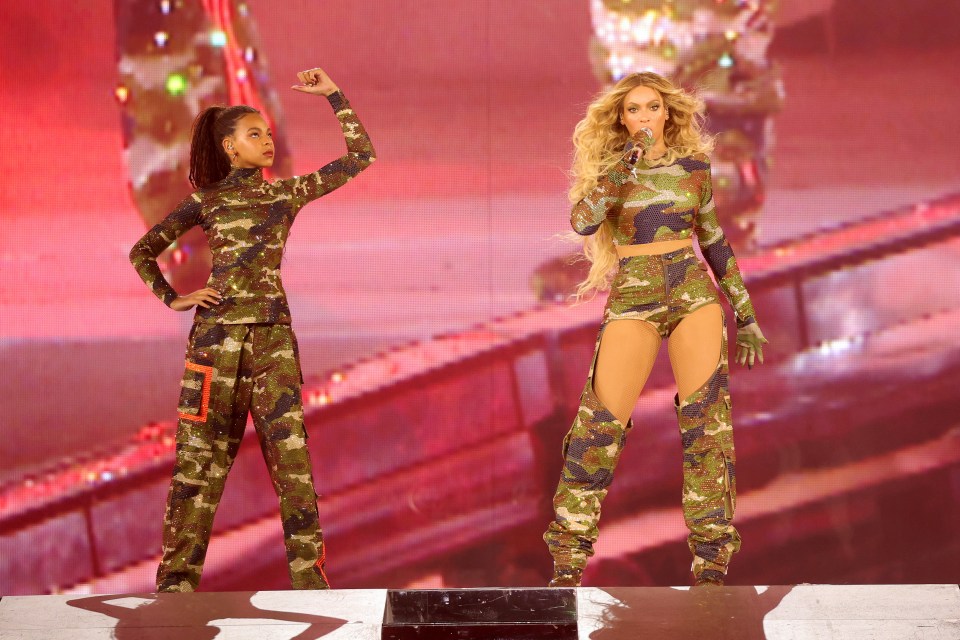 Beyoncé and Blue Ivy Carter performing onstage in camouflage outfits.