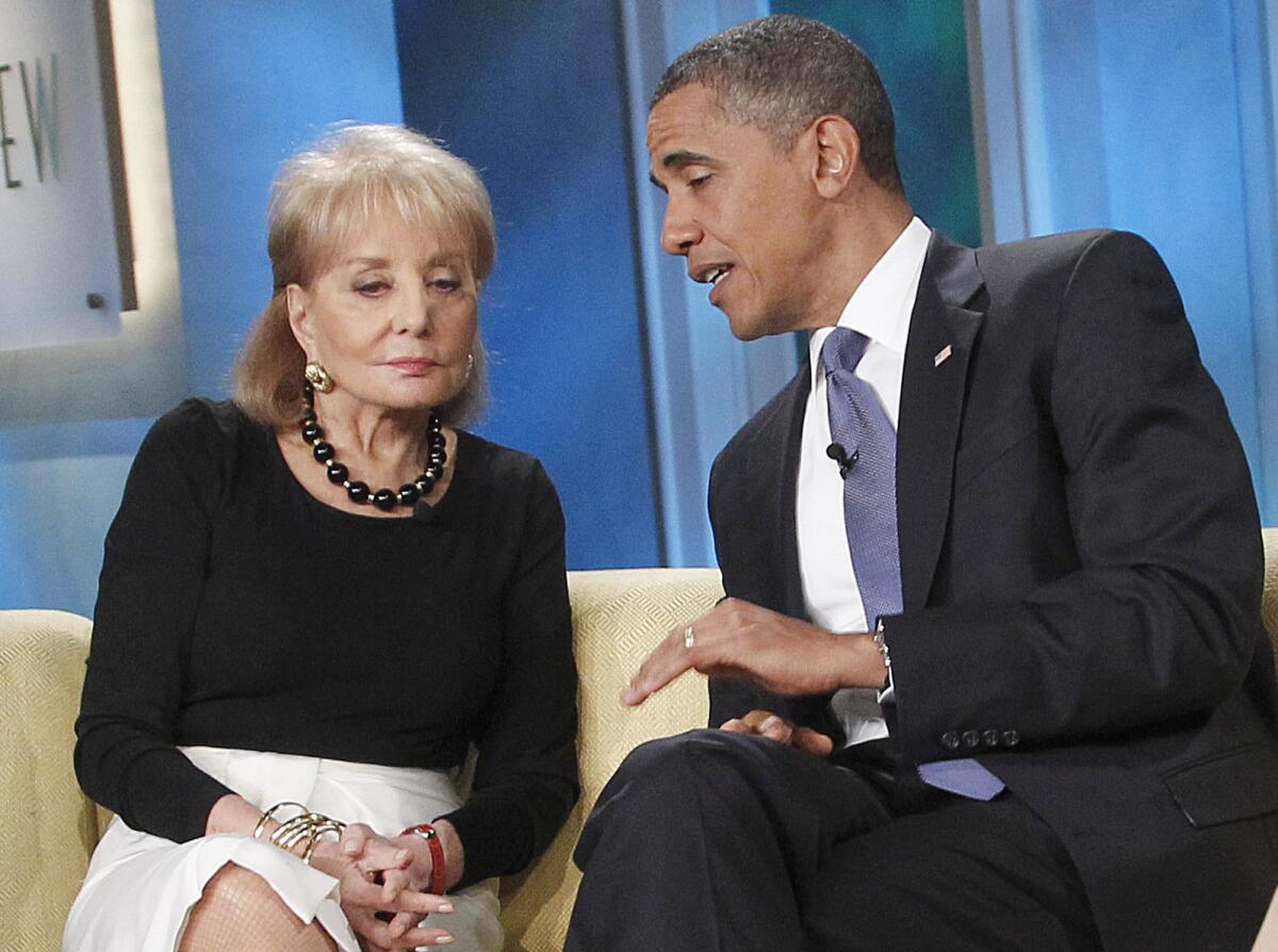 A woman in a black top and white skirt sits next to a man in a dark suit.