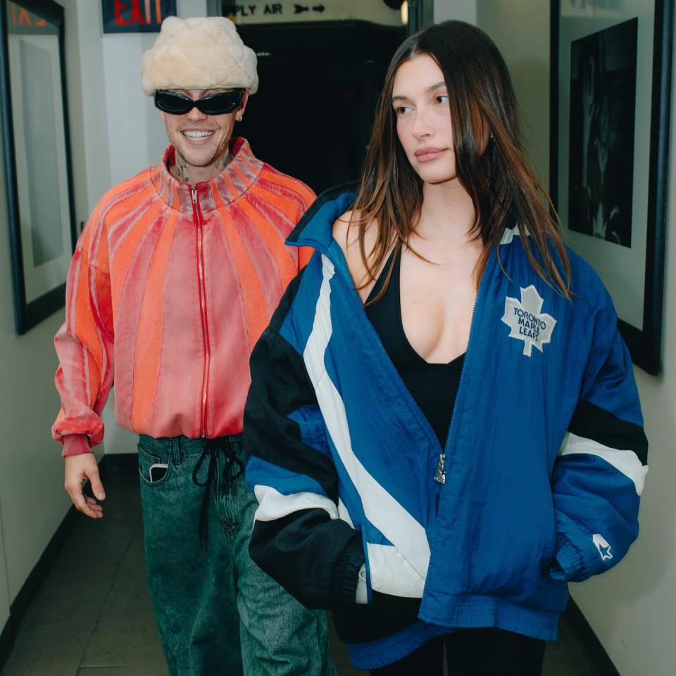 Justin Bieber and Hailey Bieber walking down a hallway.