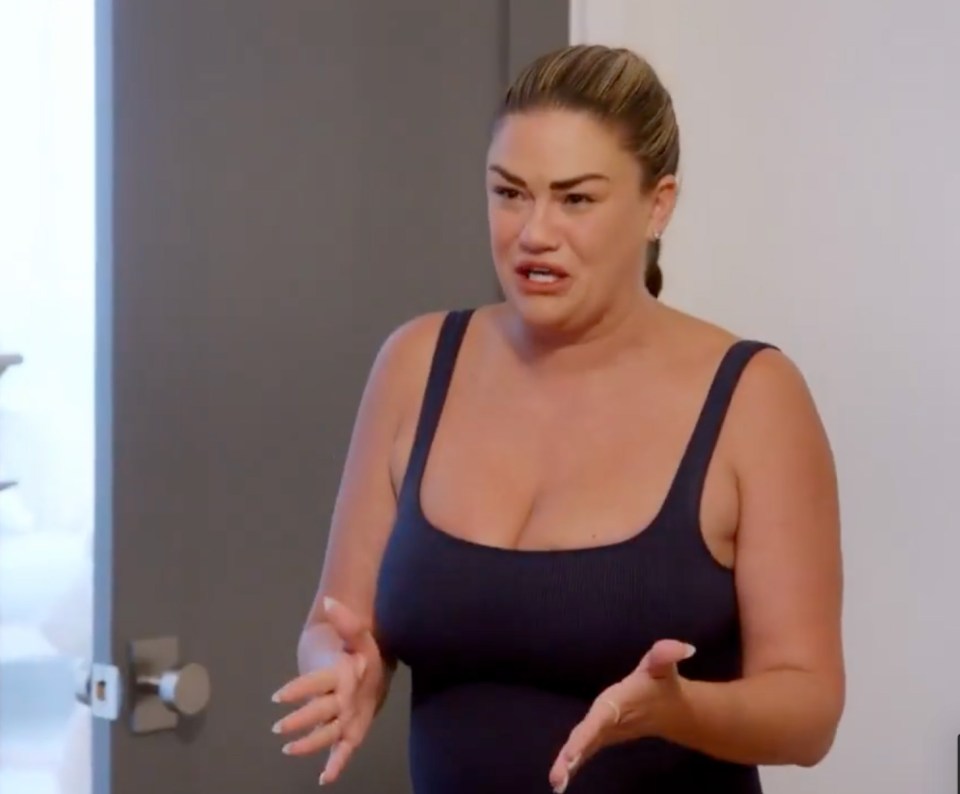Screenshot of a woman in a dark tank top, looking distressed and speaking.