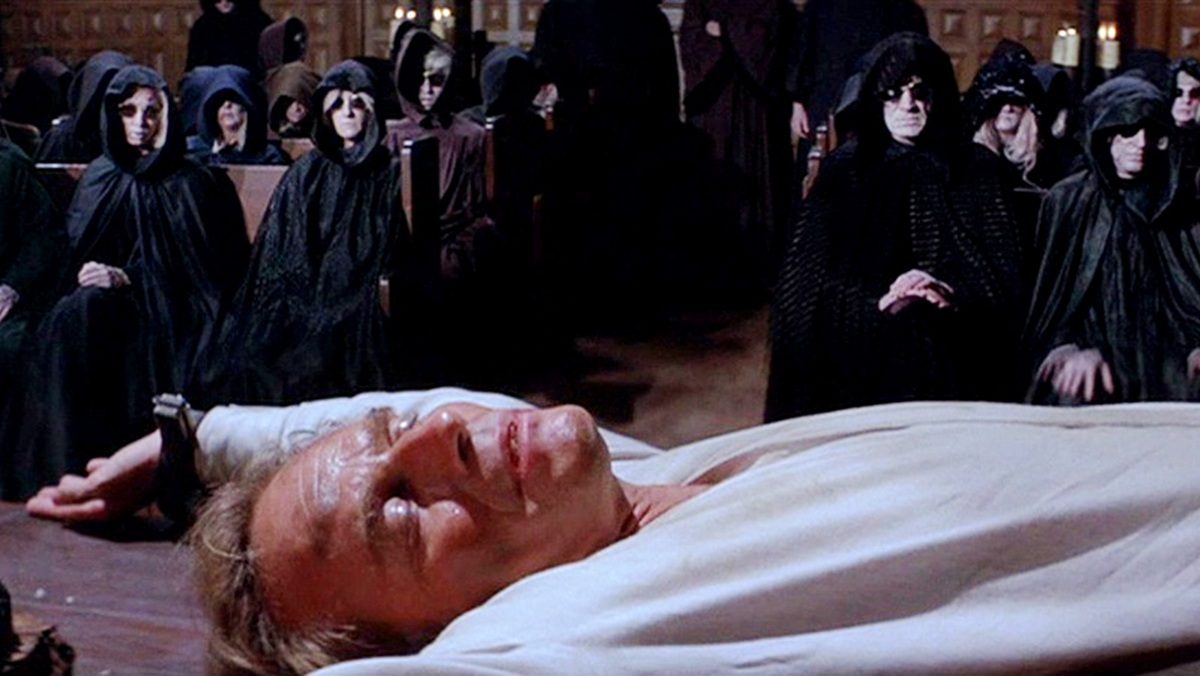 A group of cultists look at Robert Neville (Charlton Heston) in The Omega Man.