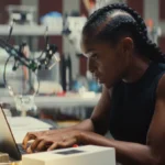 image of riri at MIT in ironheart sitting at a desk working