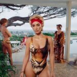Woman in tiger-print swimsuit with other women in background.