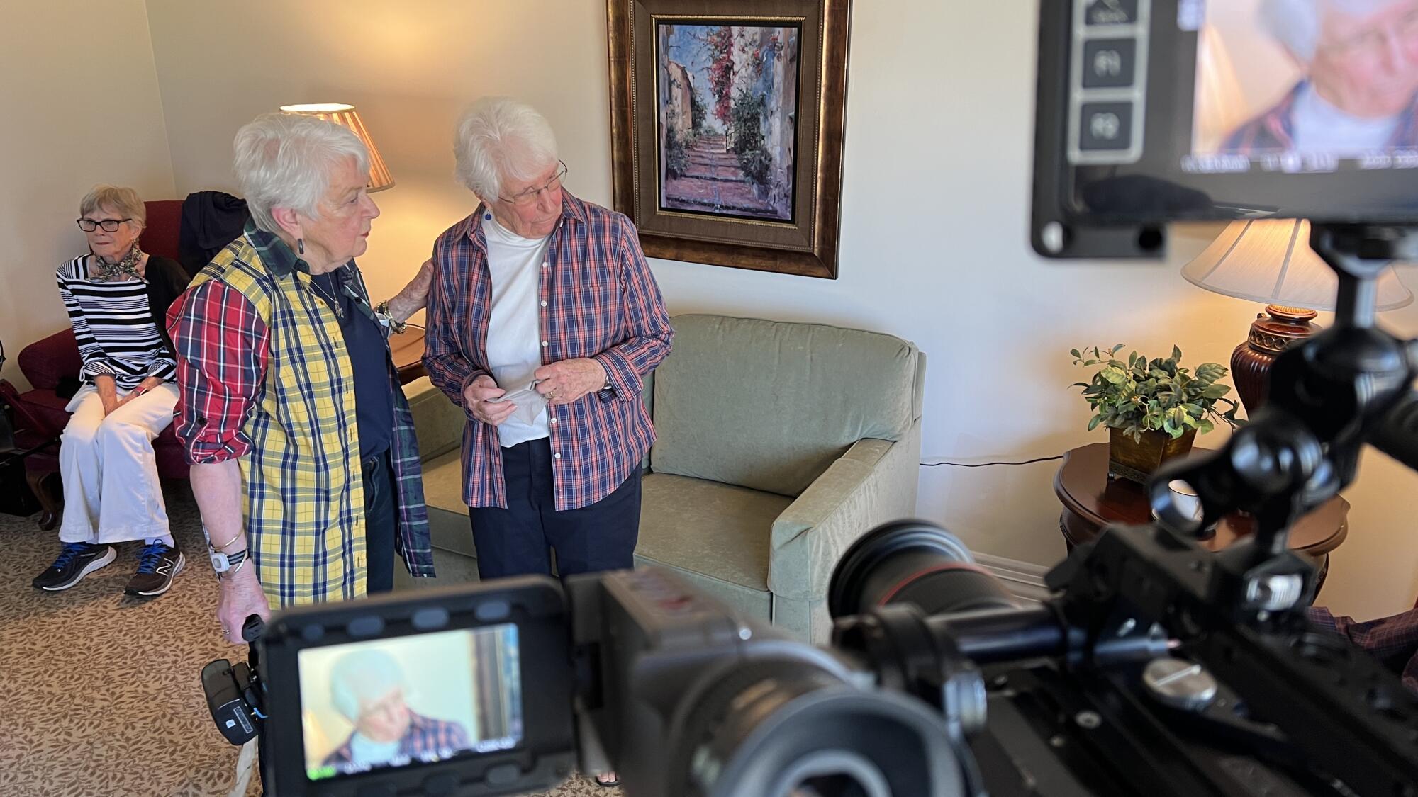 Two women have a conversation in front of a camera.