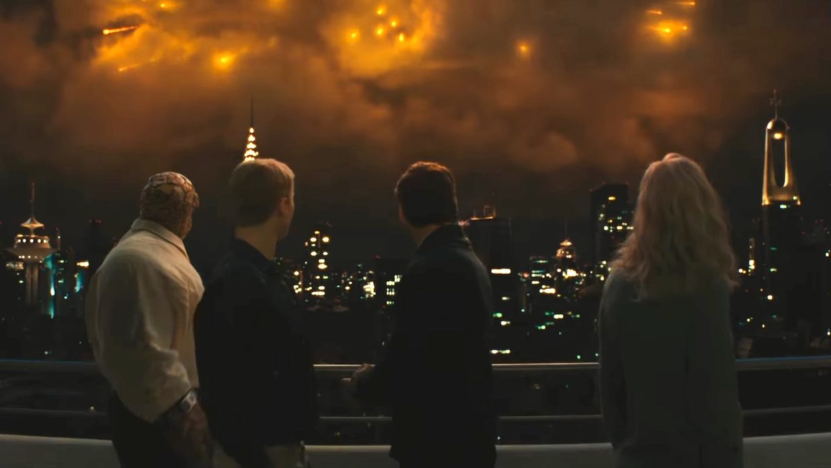 The Fantastic Four on a balcony with their backs to us looking at a terrifying glowing light in the night sky