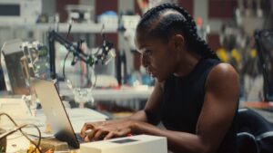 image of riri at MIT in ironheart sitting at a desk working