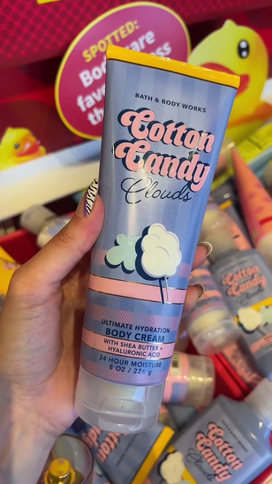 Hand holding Bath & Body Works Cotton Candy Clouds body cream.