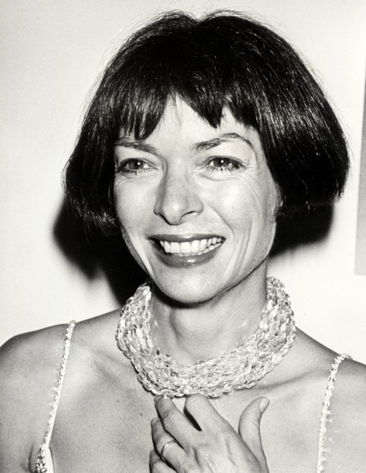 a black and white photo of a woman wearing a necklace
