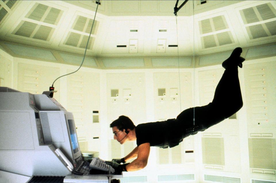 Tom Cruise using a computer while suspended in the air in Mission: Impossible.
