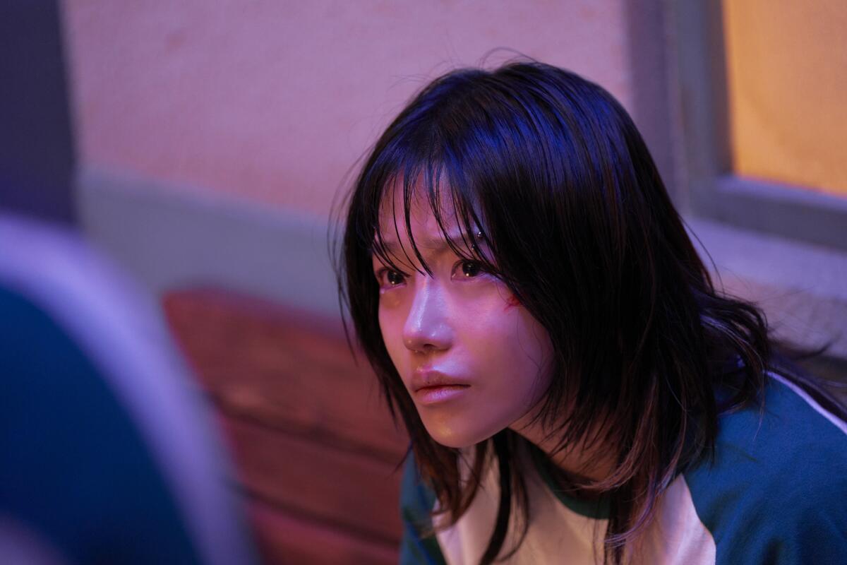 A teary-eyed woman with short black hair and bangs.