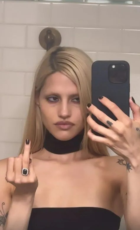 Gabbriette Bechtel giving the middle finger while taking a selfie.