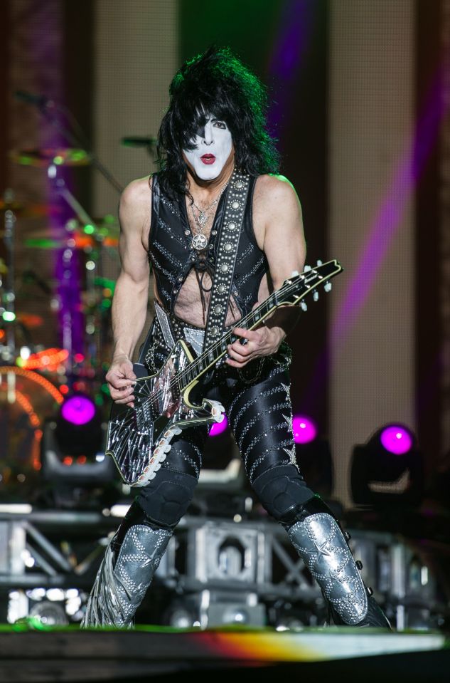 Paul Stanley of Kiss playing guitar on stage.