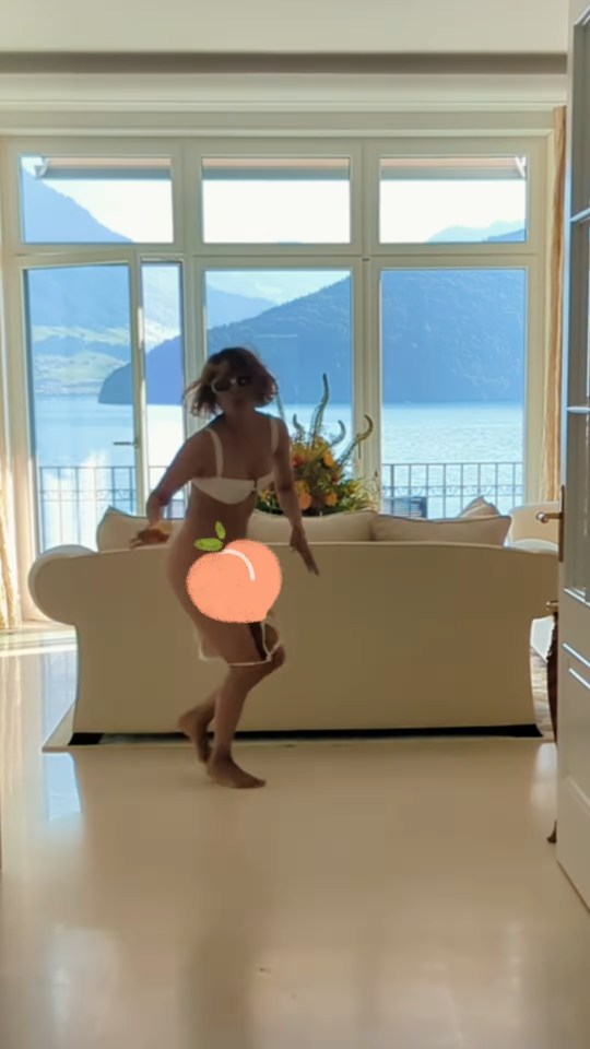 Halle Berry dancing in a room with a lake view; her bikini bottoms have fallen off.