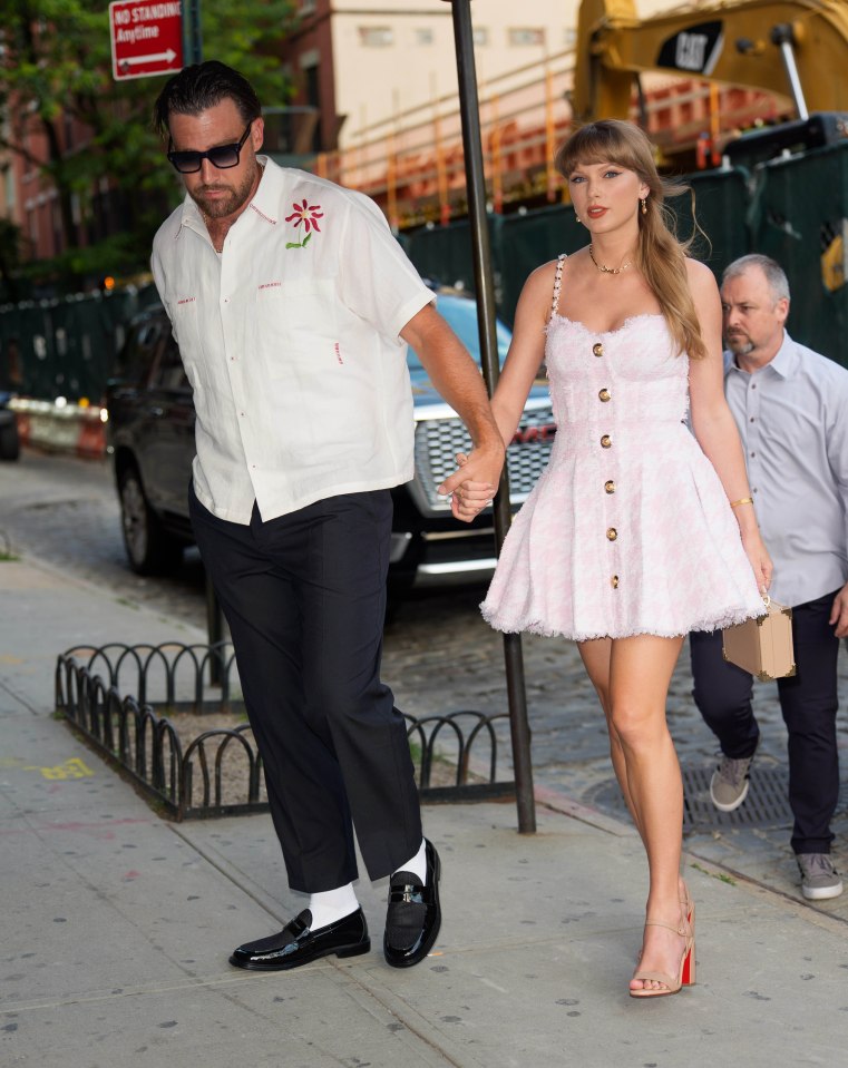 Taylor Swift and Travis Kelce holding hands while walking.