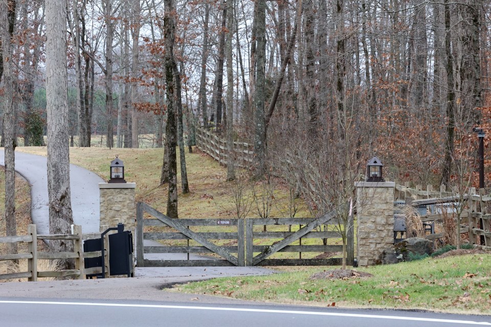 Wynonna Judd's Nashville home entrance with wooden gate and stone pillars.