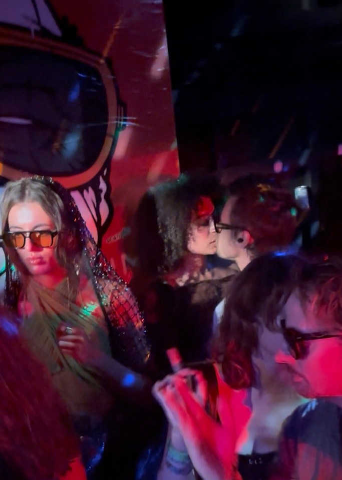 Harry Styles kissing a woman at a festival.